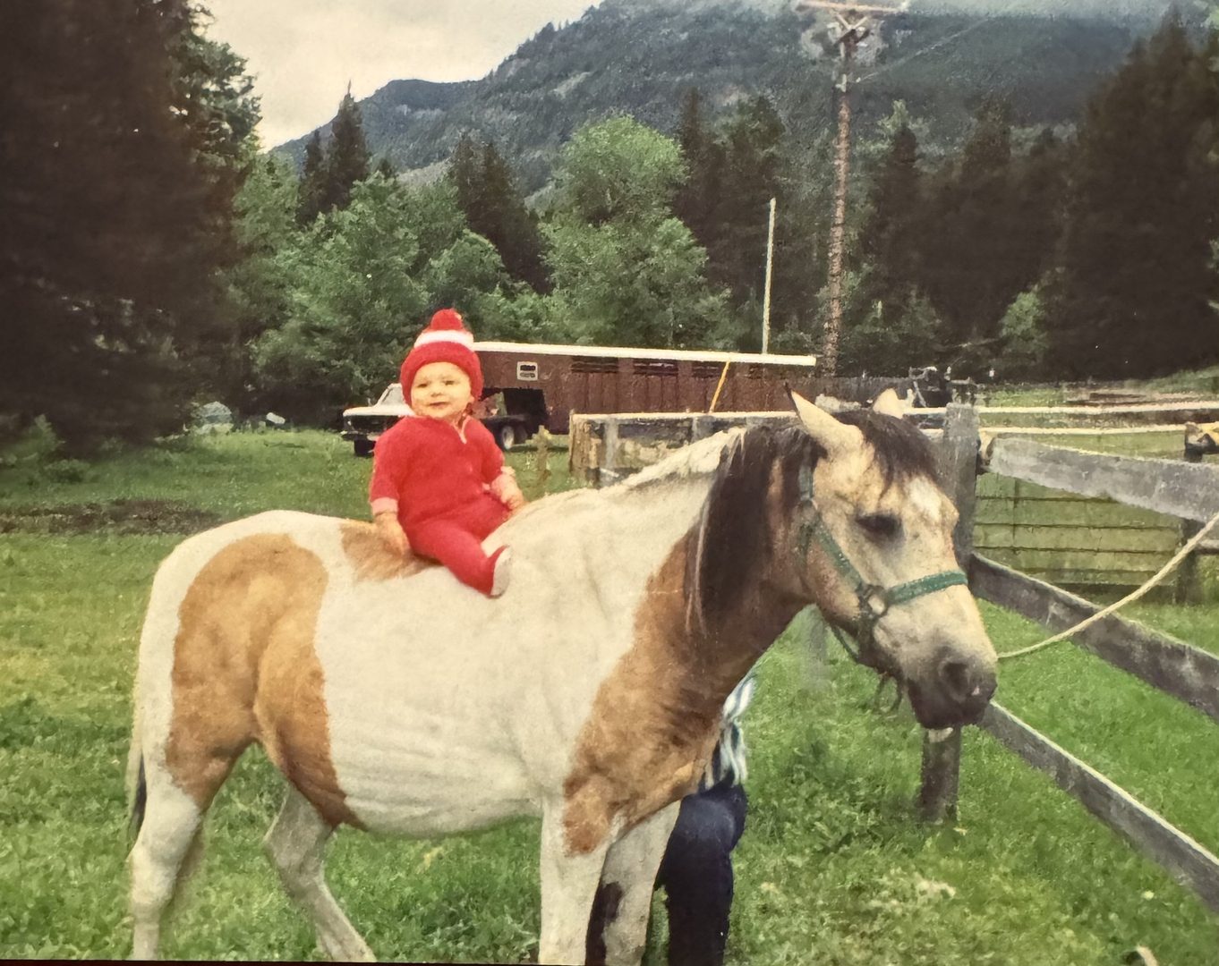 Toddler John perched on a paint horse in the Montana mountains.